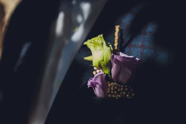 Ženich boutonniere v tmavomodré bundě. Svatební boutonniere se skládá z růžové růže, malého dianthusu a chryzantémy. Muž v bílé košili bez kravaty v bundě. — Stock fotografie