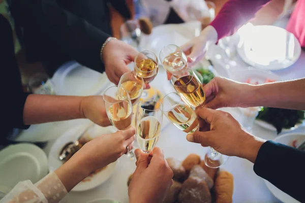 Close up shot of group of people clinking glasses with wine or champagne in front of bokeh background. older people hands. — Stock Photo, Image