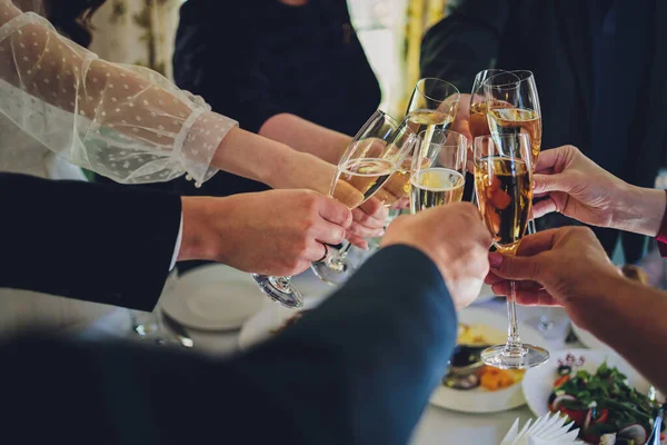 Крупный план группы людей звон стаканов с вином или шампанским на фоне боке. руки пожилых людей. — стоковое фото