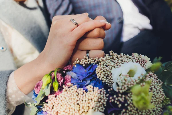 新婚夫妇手牵着五彩缤纷的婚纱的合影。新娘和新郎戴着结婚戒指。户外背景。婚礼日的概念. — 图库照片