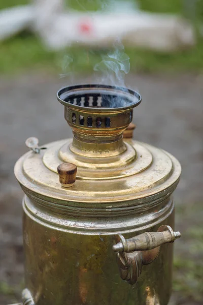Ruský samovar vaří vodu pro tradiční čajový dýchánek v přírodě. — Stock fotografie