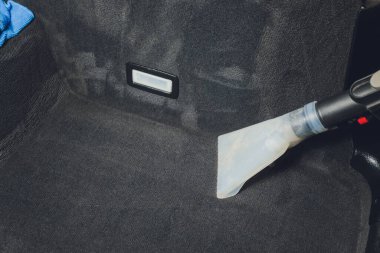 Yakışıklı genç adam, arabada profesyonel kuru temizleme salonu işletiyor. Konsept: Araba Servisi, Araba Yıkama, Kuru Temizleme Makineleri.