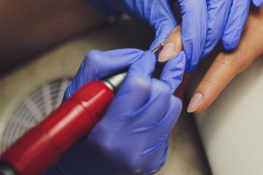 Güzellik salonunda manikür yapan bir kadın. Ellerin yakın çekimi.