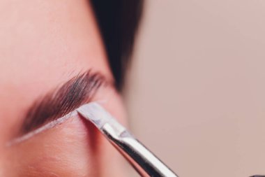 Güzellik salonunda profesyonel kaş düzeltme prosedürü olan genç bir kadın..