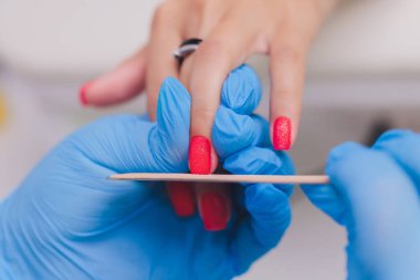 Güzellik salonunda manikür yapan bir kadın. Ellerin yakın çekimi.