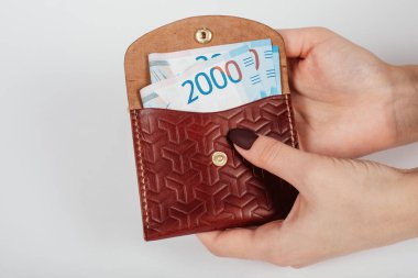 Bir kadının elleri, bir çantaya binlerce ruble para koyuyor..