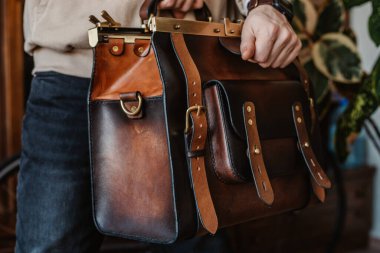 İş adamı zarif kahverengi deri evrak çantası tutuyor..