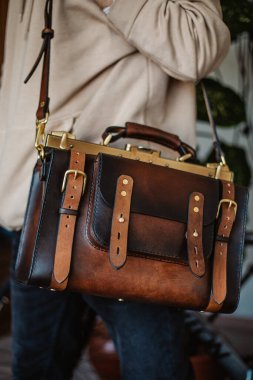 İş adamı zarif kahverengi deri evrak çantası tutuyor..