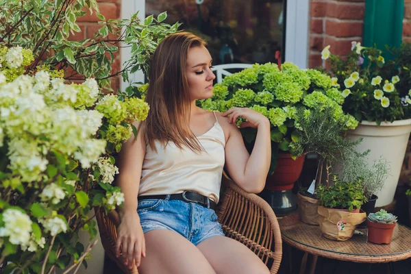 Mladá žena výběrem květin na květinovém trhu nebo v obchodě v letní den. — Stock fotografie