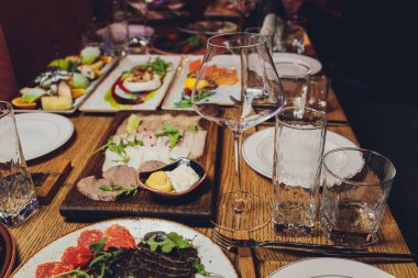Bayram ziyafet masasında servis edilen yemekler, atıştırmalıklar, çatal bıçak takımı, şarap ve su bardakları. Avrupa yemekleri.