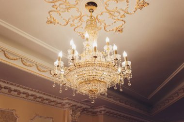 Yemek odasının tavanında kristal avize lambası. Görüntüyü lüks bir tonda ayarlıyor. Dekoratif zarif ve çağdaş iç mekan kavramı..