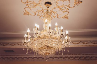 Yemek odasının tavanında kristal avize lambası. Görüntüyü lüks bir tonda ayarlıyor. Dekoratif zarif ve çağdaş iç mekan kavramı..