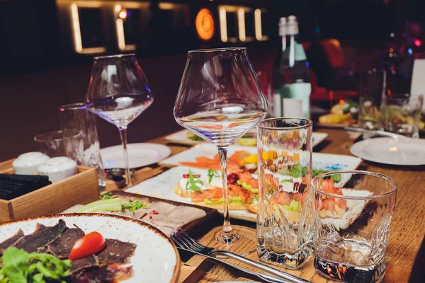 Geserveerd voor vakantie banket restaurant tafel met gerechten, snack, bestek, wijn en water glazen. Europese levensmiddelen. — Stockfoto