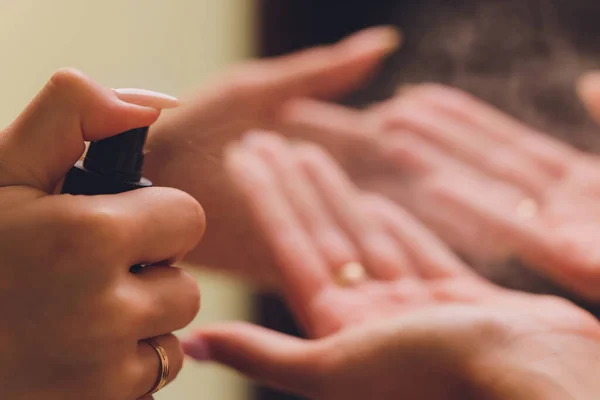 Mutter und Tochter tragen Alkohol- oder Antibakterienspray auf die Hände auf, um die Ausbreitung von Keimen zu verhindern. Persönliches Hygienekonzept. — Stockfoto