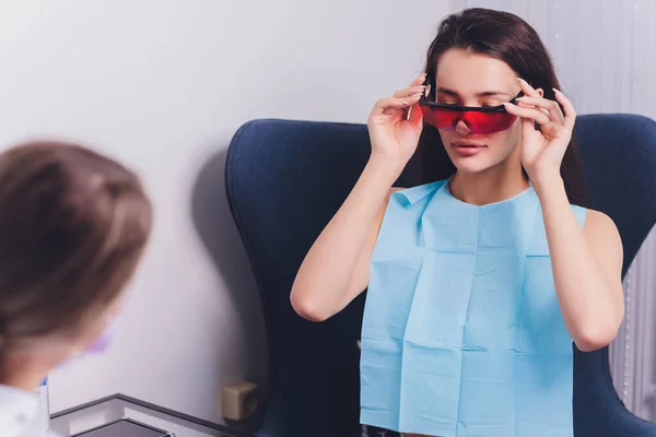 Close-up portret van een vrouwelijke patiënt bezoeken tandarts voor het bleken van tanden in kliniek, Teeth whitening procedure. — Stockfoto