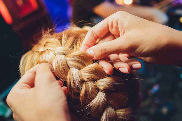 Proces pletení mistr plete copánky na hlavě blond holčička v salonu krásy zblízka. Profesionální péče o vlasy a vytváření účesů. — Stock fotografie