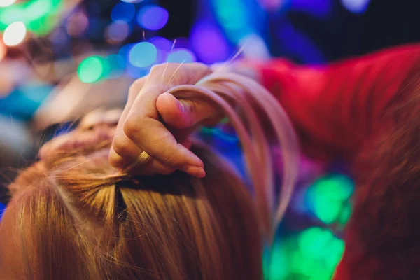 Processo de trançar o mestre tece tranças em sua cabeça menina loira no salão de beleza de perto. Cuidados com o cabelo profissional e criação de penteados. — Fotografia de Stock