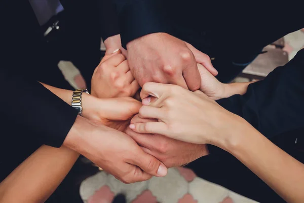 Два чоловіка і три жінки тримають руки на столі, маючи на увазі поліаморіальні відносини або любовний трикутник . — стокове фото