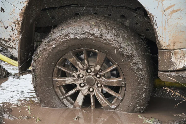 Çamurlu bir yolu olan kırsal bir arazide tekerlek yakın..