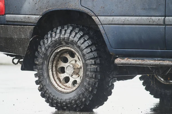 Hjul närbild i ett landsbygdslandskap med en lerig väg. — Stockfoto