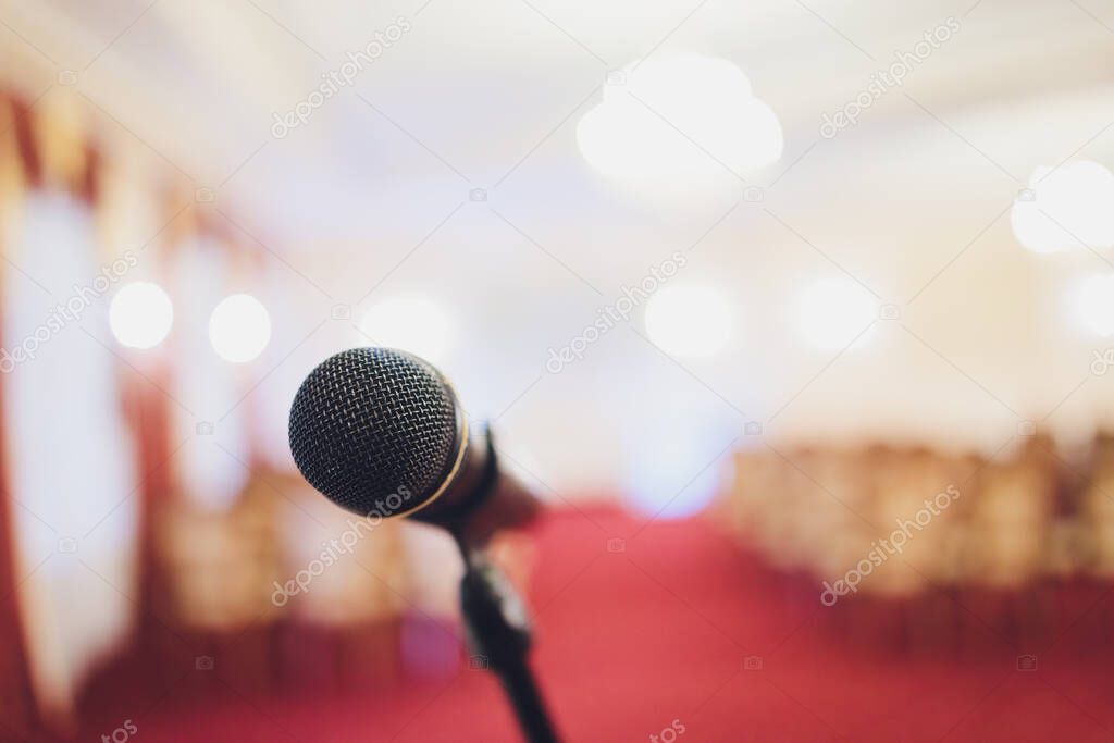 Front close up Microphone over blurred empty on the hall. Microphone on stage. Ceremony in the hall.