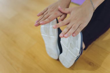 Fitness sporcuları ayaklarınızı yakın plan çekin. Sağlıklı yaşam tarzı ve spor kavramları. Şık spor elbiseli kadın egzersiz yapıyor..