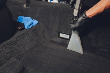 Yakışıklı genç adam, arabada profesyonel kuru temizleme salonu işletiyor. Konsept: Araba Servisi, Araba Yıkama, Kuru Temizleme Makineleri.