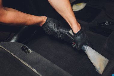 Yakışıklı genç adam, arabada profesyonel kuru temizleme salonu işletiyor. Konsept: Araba Servisi, Araba Yıkama, Kuru Temizleme Makineleri.