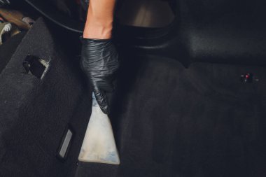 Yakışıklı genç adam, arabada profesyonel kuru temizleme salonu işletiyor. Konsept: Araba Servisi, Araba Yıkama, Kuru Temizleme Makineleri.