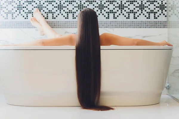 Schöne Frau im Badezimmer mit langen Haaren. — Stockfoto