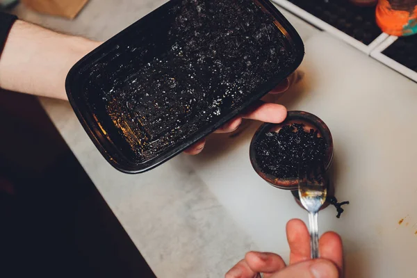 Una persona toma tabaco. La persona está preparando un narguile. Hay una mesa.. —  Fotos de Stock