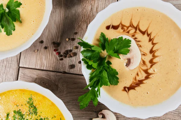 Different kinds of soups - pumpkin soup, cheese cream-soup and mushroom cream-soup on the table. — Stock Image Different kinds of soups - pumpkin soup, cheese cream-soup and mushroom cream-soup on the table. Royalty Free Stock Images