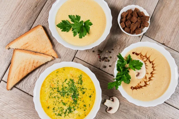 Different kinds of soups - pumpkin soup, cheese cream-soup and mushroom cream-soup on the table. — Stock Image Different kinds of soups - pumpkin soup, cheese cream-soup and mushroom cream-soup on the table. Stock Image