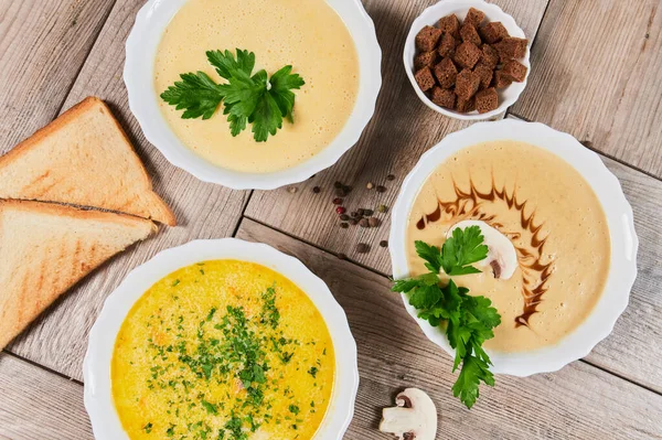 Different kinds of soups - pumpkin soup, cheese cream-soup and mushroom cream-soup on the table. — Stock Image Different kinds of soups - pumpkin soup, cheese cream-soup and mushroom cream-soup on the table. Royalty Free Stock Images