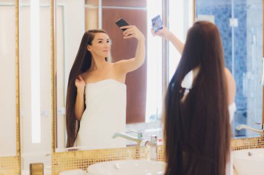 Güzel gülümseme mutlu kadın gülümse ve aynayla selfie çek. Asyalı güzellik.