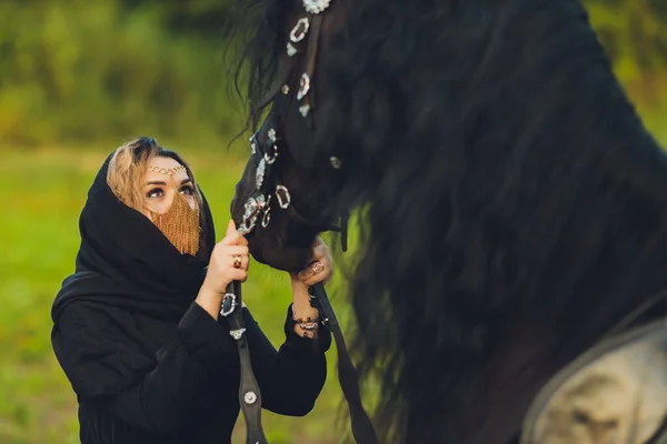 Mujer musulmana en hiyab montando un caballo. — Foto de Stock