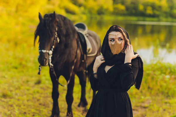 Muselman kvinna i hijab rida en häst. — Stockfoto