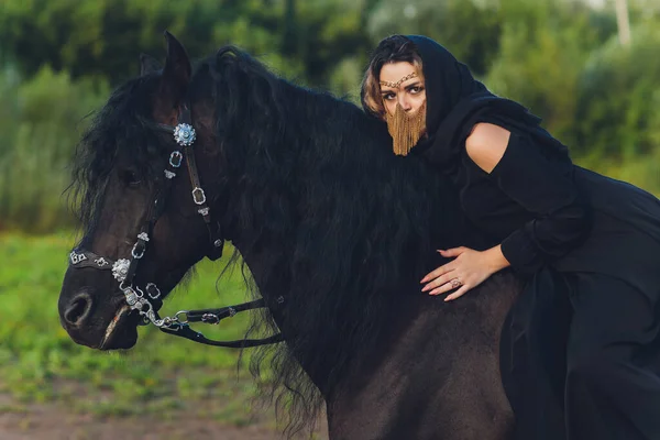 Mujer musulmana en hiyab montando un caballo. — Foto de Stock