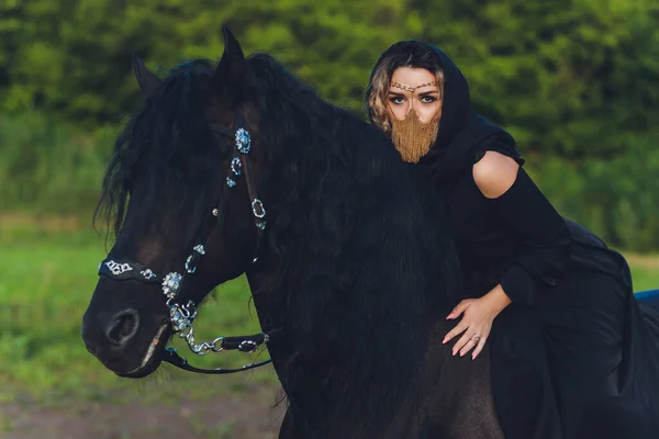 Mujer musulmana en hiyab montando un caballo. — Foto de Stock