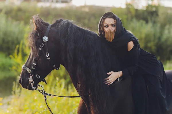 Mujer musulmana en hiyab montando un caballo. — Foto de Stock
