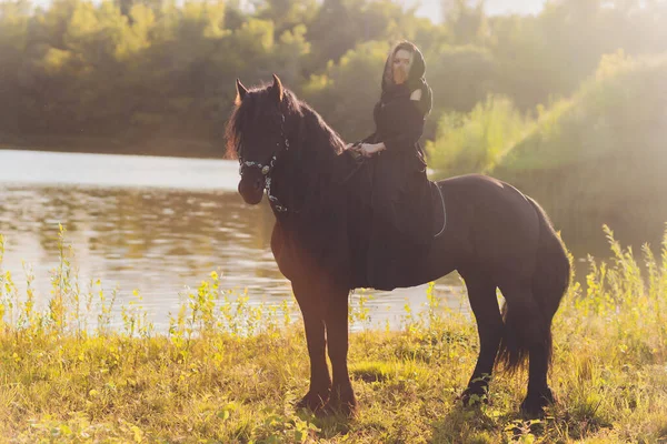 Mulher muçulmana no hijab montando um cavalo. — Fotografia de Stock