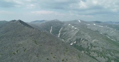Magadan bölgesindeki kızıl dağların arasında yeşil orman.