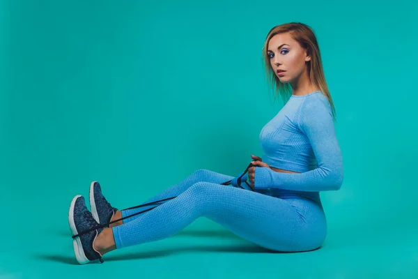 Närbild av sportig ung kvinna med muskulös kropp på turkos bakgrund med kopia utrymme. Sport och hälsosam livsstil. — Stockfoto