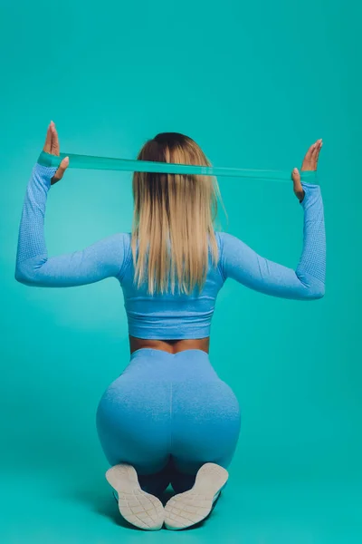 Gros plan de la jeune femme sportive au corps musclé sur fond turquoise avec espace de copie. Sport et mode de vie sain. — Photo