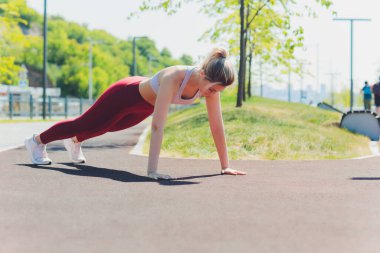 Genç sporcu kadın, esneme hareketleri yapıyor..