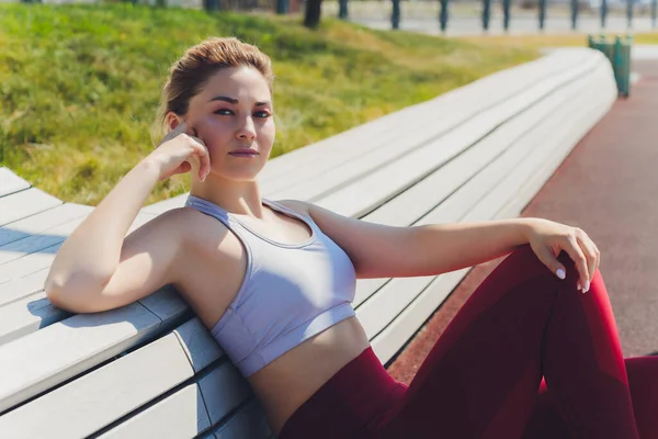 Una joven se está preparando para los deportes al aire libre en el moderno paseo marítimo cerca de su complejo de apartamentos. — Foto de Stock