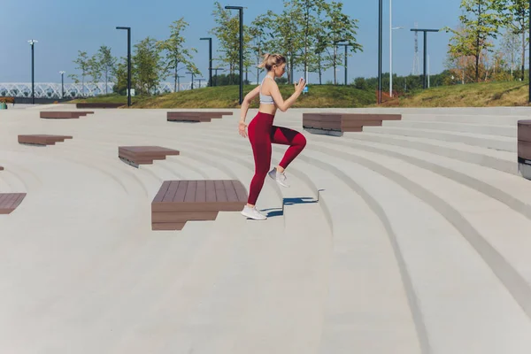 Γυναίκα που τρέχει. Ο δρομέας κάνει τζόκινγκ την αυγή. Γυναικεία προπόνηση μοντέλου γυμναστικής έξω στην πόλη σε μια προβλήτα. Αθλητικός τρόπος ζωής. — Φωτογραφία Αρχείου