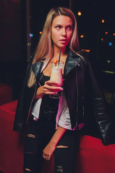 Mulher feliz em uma festa sorrindo e segurando uma bebida. — Fotografia de Stock