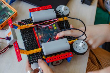 Robot bilimleri dersinde öğrenci, robot inşaatçıları topla..