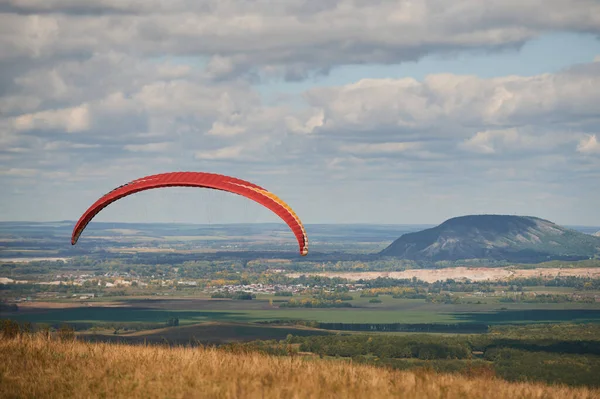 One paraglider is flying in the blue sky against the background of clouds. Paragliding in the sky on a sunny day. — Stock Photo, Image